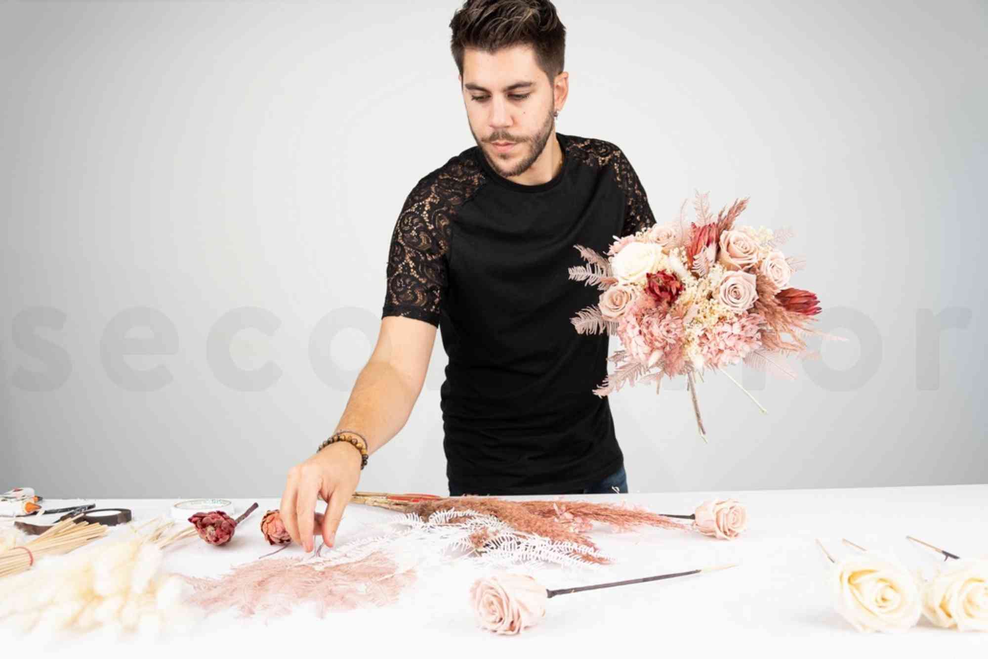 the florist is holding the bouquet almost finished